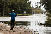 A pedestrian checks out the conditions on Dr. Martin Luther King Street at 26th Avenue S with flooding from Lake Maggiore after Hurricane Milton on Oct. 11. [ DIRK SHADD | Times ]