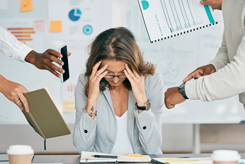 woman has her hands on her head as others stand around her