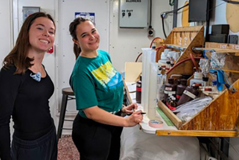 Students smiling in a research lab while doing a project