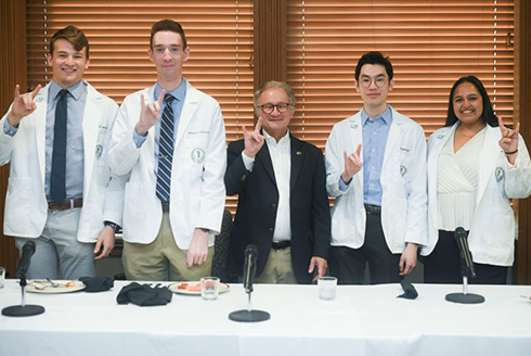 Dr. Charles Lockwood gives the Go Bulls hand signal with other MD/PhD students