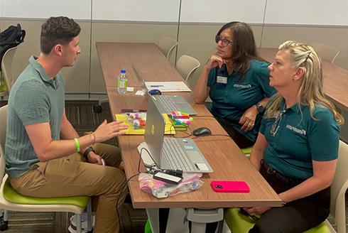 Three people sit at a table