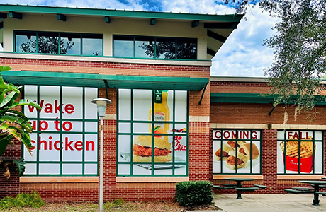 Chick-fil-a signage in the windows of a brick building