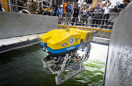 The remotely operated vehicle Taurus behing lowered into the water from the Western Flyer's moon pool.