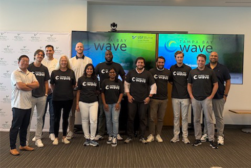 Group of business owners in front of monitor that says Tampa Bay Wave