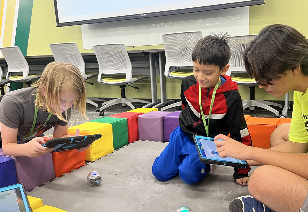 C.A.G.E. Elementary CyberCamp students use tablets to learn coding.