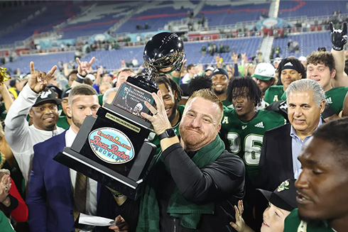 USF football team holds Boca Bowl trophy