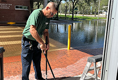 Man cleans up broken glass during Hurricane Milton