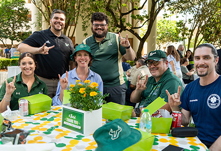 USF employees give the "Go Bulls" hand signal