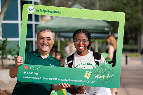 Students holding usf st Petersburg instagram sign up to frame their faces like a Photo Booth