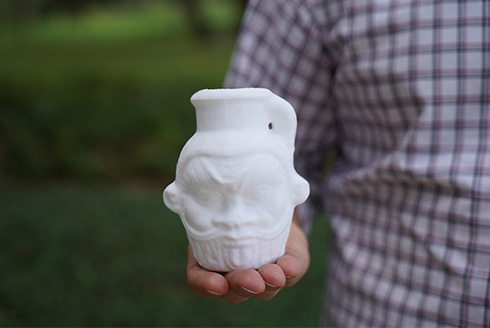 close up of Davide holding the 3D printed replica of the mug