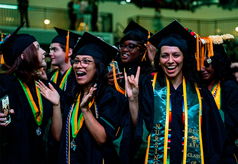 Nursing students at commencement give Go Bulls signal