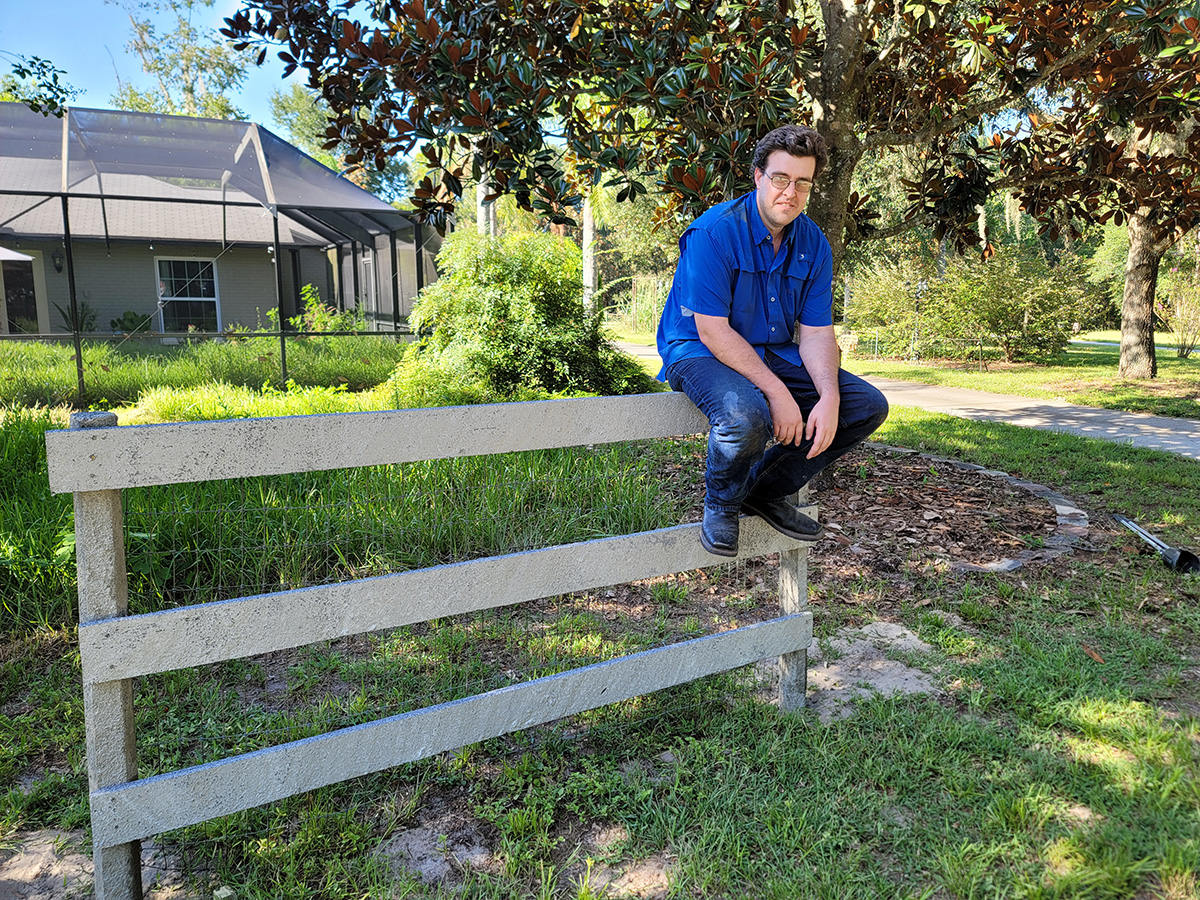 John cotter sitting on his new fence invention