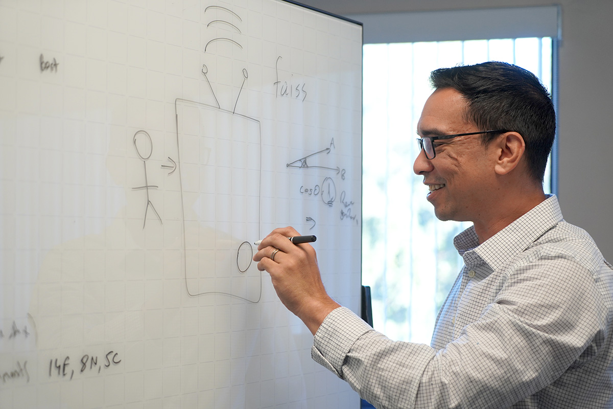 john licato drawing his design for the app on a white board