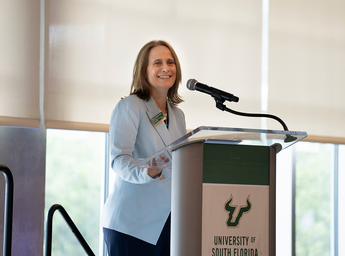 Shelly at event speaking at podium