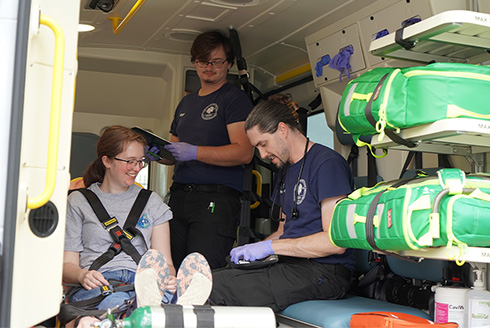 Student sits in an ambulance being trained on infectious disease control