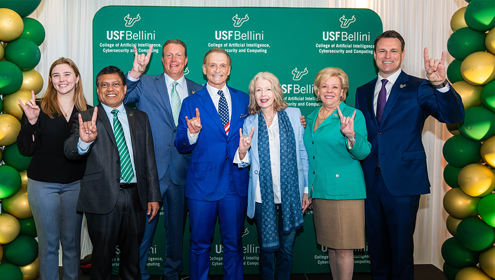 Group poses infront of new USF Bellini College backdrop