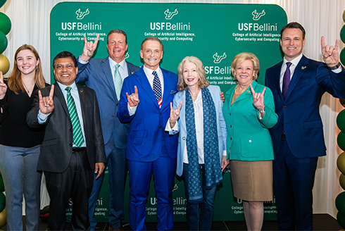 Group poses infront of new USF Bellini College backdrop