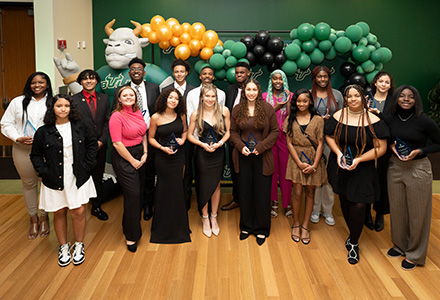 Students hold up awards during banquet