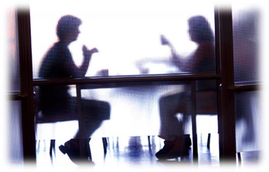 Two people in a confidential 1:1 meeting