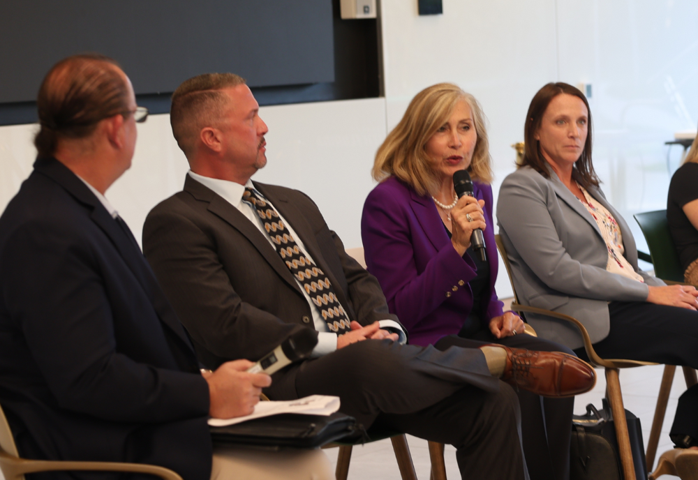 Four GNSI panelists sit in a row while addressing students about their national and international security careers.