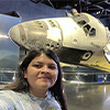 Female student Andrea Coloma poses in front of a space shuttle at NASA