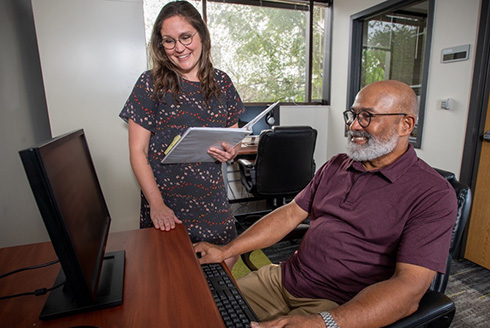 Researcher watches man taking test on computer