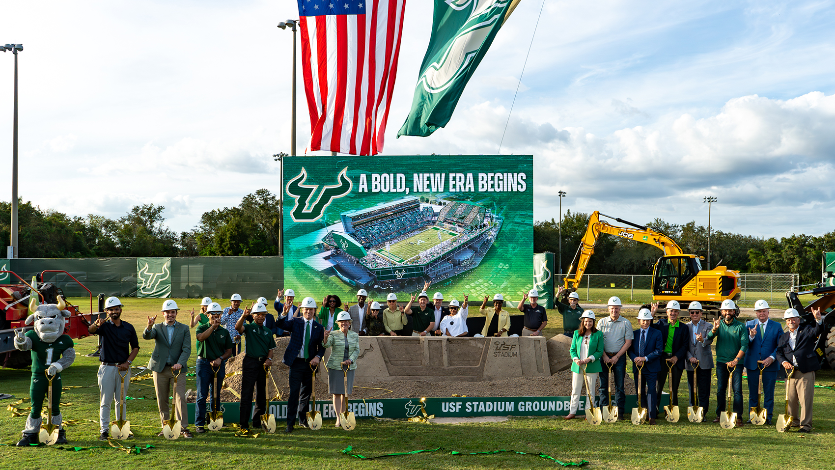 USF Leadership and Rocky the Bull pose with the "Bull U" hand sign in front of the groundbreaking site