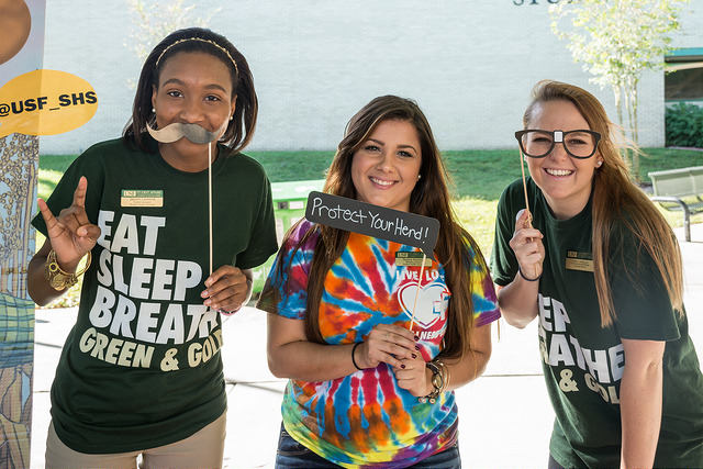 iamge of students with wellness week photo booth props