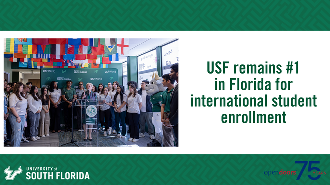 President Law speaking at a lectern surrounded by USF international students on a green and white background