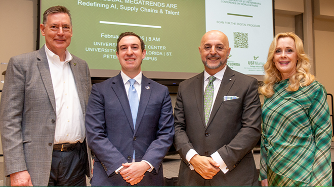 President Law speaking at a lectern surrounded by USF international students on a green and white background