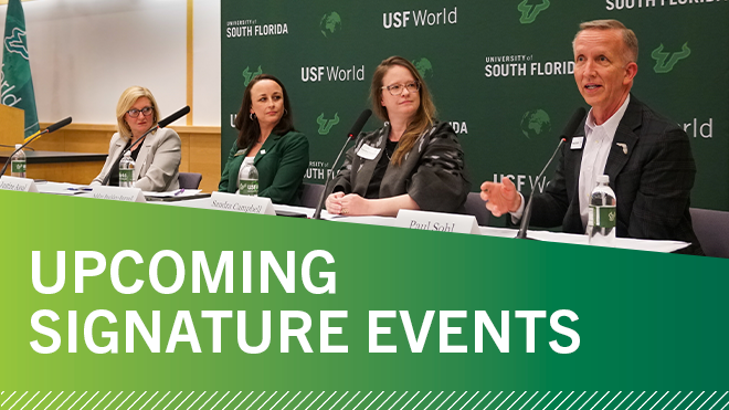 Panelists lined up in front of USF World green backdrop