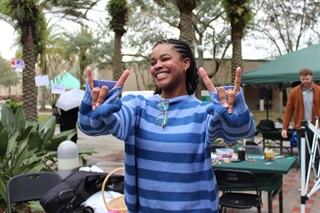 USF international student from Brazil posing with her fingers up in a "bulls" pose for the camera
