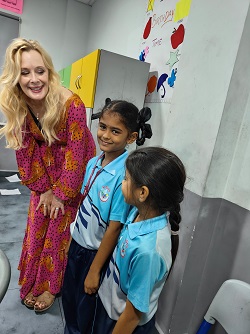 Dr. Kiki Caruson interacting with two students from the Next Gen International School in India.