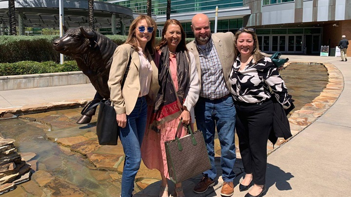 2 female world languages professors from UniNorte in Colombia and USF pose in front of the iconic USF bull with a male and female representative from USF World