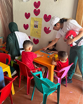 nursing student leaning over table by three children in a classroom setting