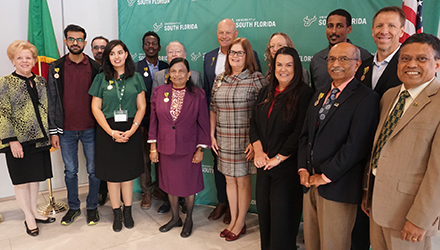 A group of scholars and USF representatives, President Rhea Law on the left and the campus provost on the right