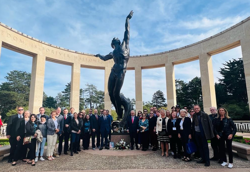 Tampa and Le Havre delgation posing for a photo after participating in a wreath-laying ceremony at the World War II American Cemetery near Omaha Beach in France.