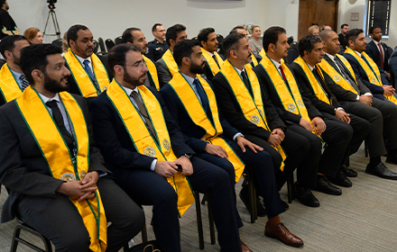 People sitting in conference room with yellow sashes