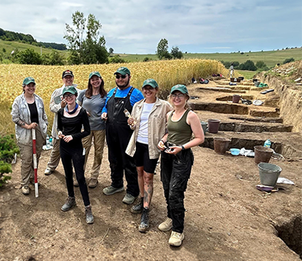 students stand at burial site in transylvania