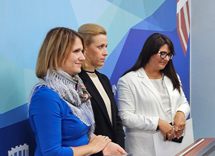 Three presenters standing in front of a room