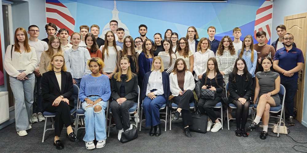 A group of college students standing in a classroom