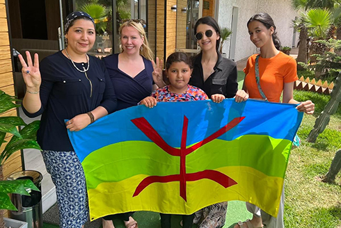 Heide Castañeda (second from left) poses with the Amazigh flag on a recent trip to Morocco