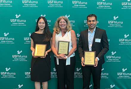 Kalam fellows holding awards in front of USF Bulls green background