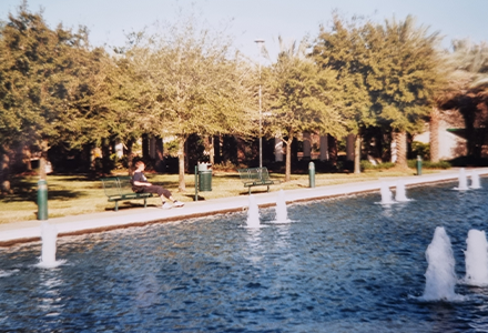 student on USF campus in front of a pool