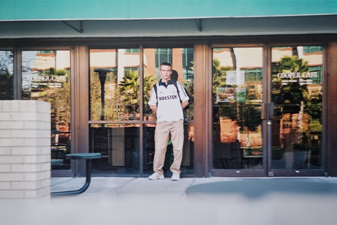 a student standing in front of a USF building