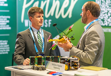 two people talking at a USF booth