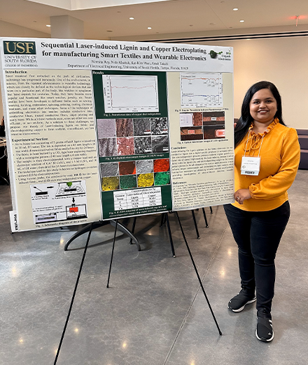 Nirmita in a yellow shirt, presenting a board filled with information