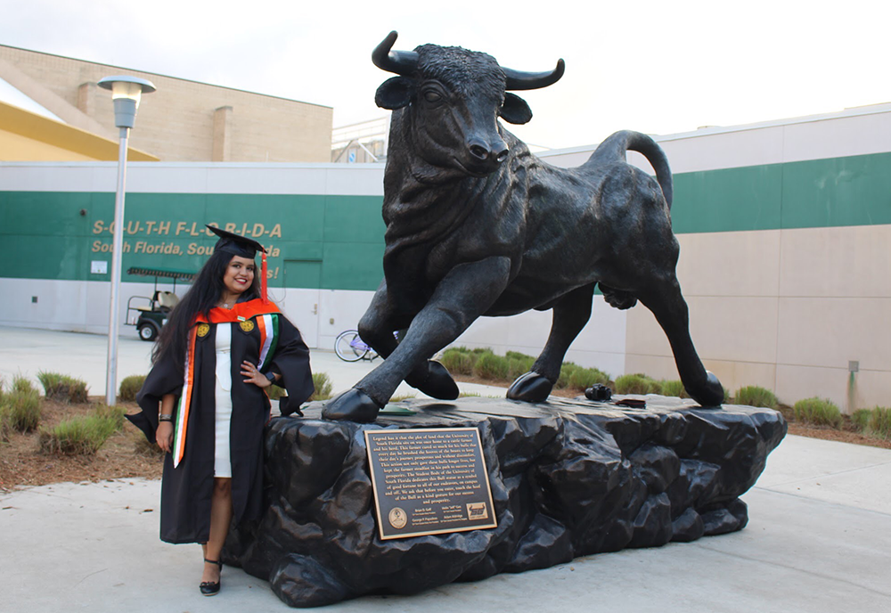 Nirmita standing by the USF bull statue