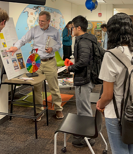 A USF representative is pointing to a board with safety information