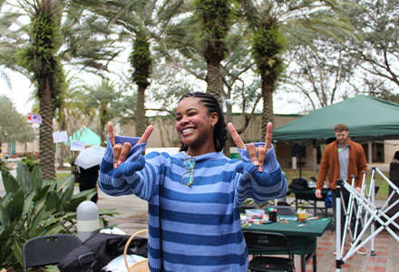 USF international student from Brazil posing with her fingers up in a "bulls" pose for the camera